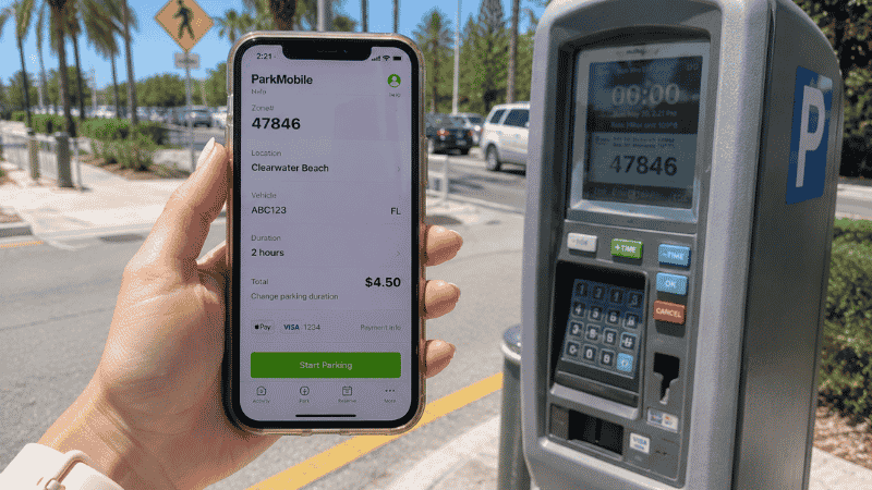 Person using ParkMobile app on smartphone to pay for parking at Clearwater Beach Florida