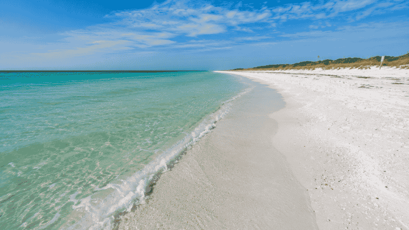 Pristine white sand beach at Henderson Beach State Park in Destin Florida with emerald Gulf water