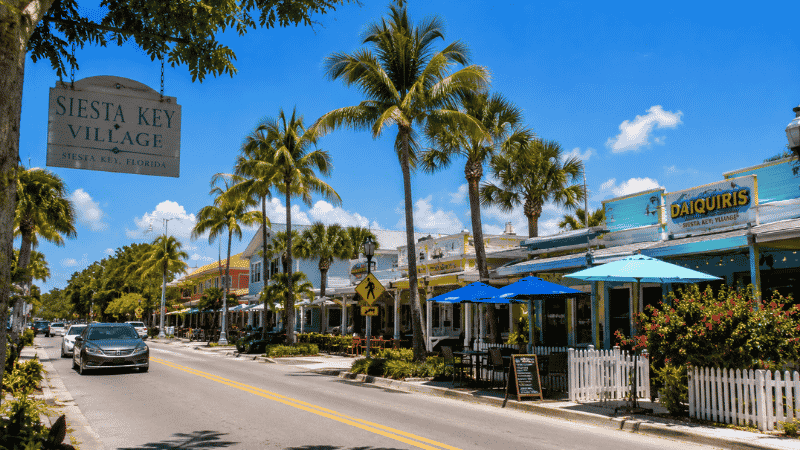 Siesta Key Village beach town street with colorful shops restaurants and palm trees in Florida