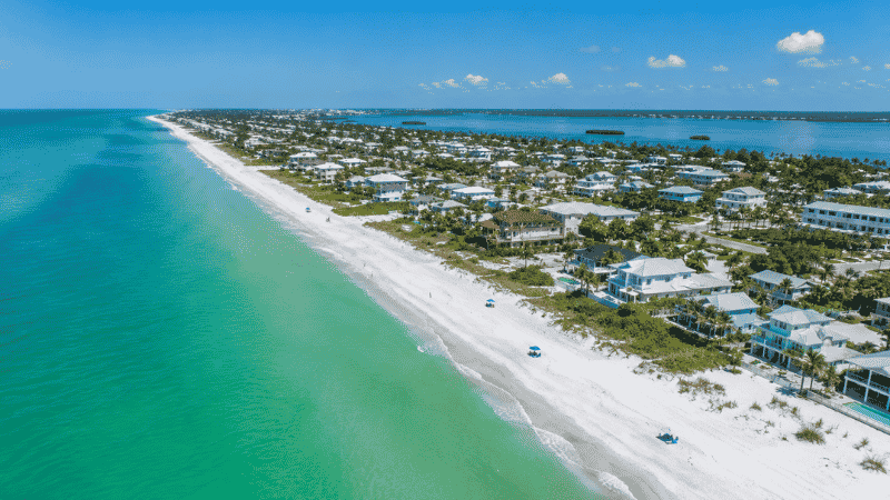 Aerial view of Anna Maria Island Florida showing seven miles of white quartz sand beach with turquoise Gulf water and low-rise beach cottages