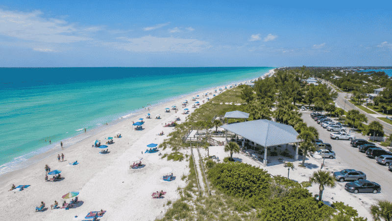 Bean Point at Anna Maria Island Florida showing white sand beach where Gulf of Mexico meets Tampa Bay at golden sunset