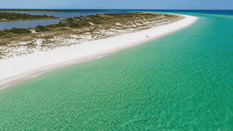 Pristine Shell Island barrier island near Panama City Beach Florida with crystal clear emerald water