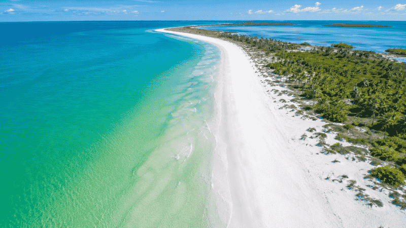 Aerial panoramic view of Florida Gulf Coast beach with brilliant white quartz sand and turquoise to emerald green Gulf water