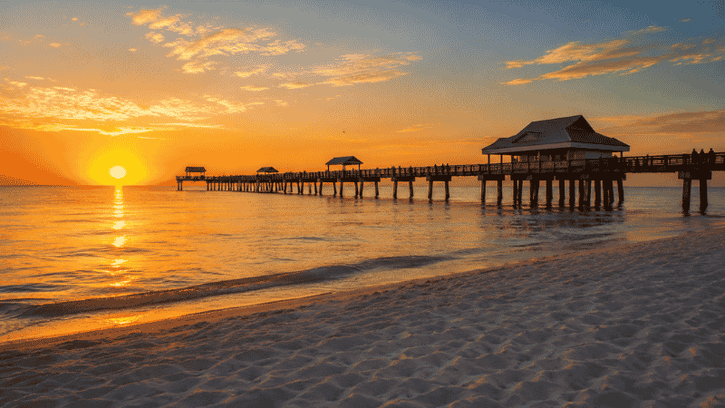 Clearwater Beach Florida Pier 60 at sunset with warm golden sky reflecting on calm Gulf water rated number 2 US beach 2026