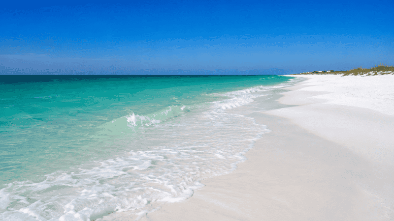 Destin Florida Panhandle beach showing signature emerald green Gulf water and sugar white sand on a clear day
