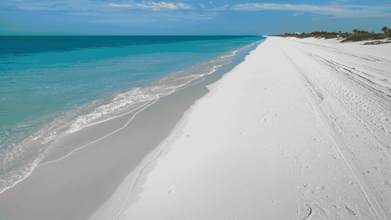 A detailed close-up of the ultra-fine, 99% pure white quartz sand at Siesta Key Beach that stays cool to the touch even in direct sunlight.